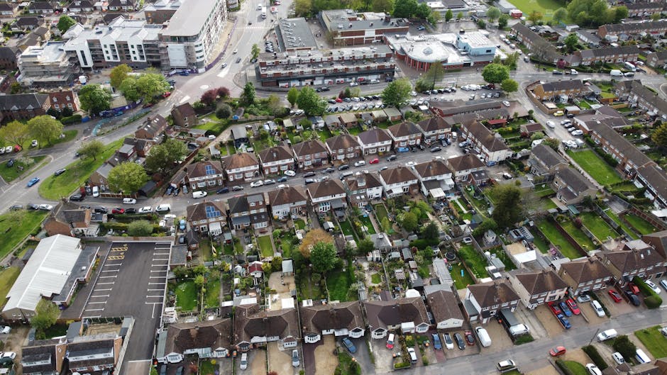 Aerial view of a residential neighbourhood during daytime showing a row of terraced houses with small front gardens and backyards. The houses are closely spaced with narrow streets running between the